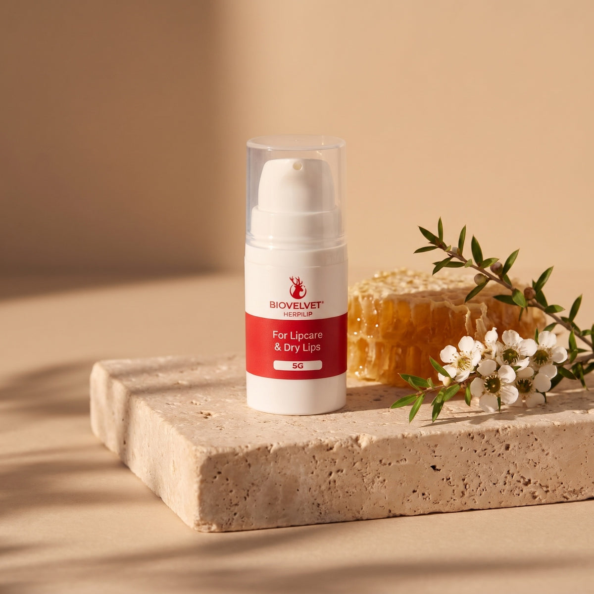 BIOVELVET Herpilip 5g pump on travertine with honeycomb and manuka flowers